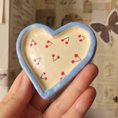 a hand holding a ceramic heart shaped object