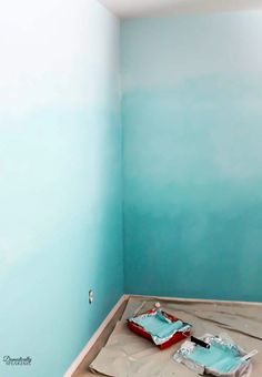 an empty room painted in blue and white with some items laying on the floor next to it