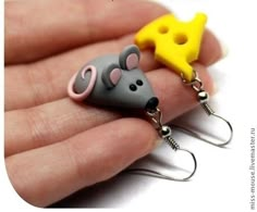 a hand holding two tiny mouses with cheese on them's back and one in the foreground