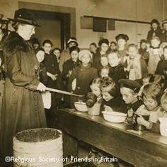 an old black and white photo of some people in a room with many bowls on the table