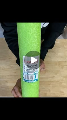 a person is holding a roll of neon green paper