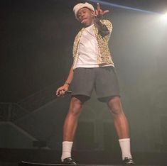 a male in a white shirt and black shorts on a stage