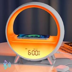 an alarm clock sitting on top of a table next to a cell phone and remote control