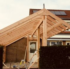 a house being built with wooden framing and roof trusss on the front of it