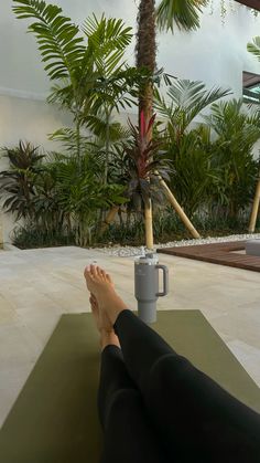 a person is sitting on a mat with their feet propped up next to a coffee cup