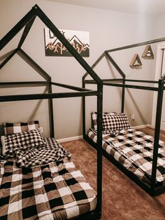 two black and white checkered beds in a room with carpeted flooring, one is made out of metal frames