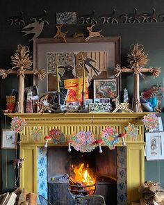 a fireplace with pictures and decorations above it