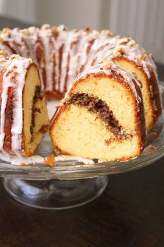 a bundt cake with white icing and walnuts on top is cut in half