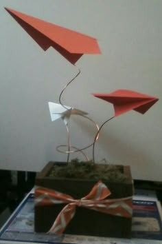 an origami bird sculpture on top of a box with a bow tied around it