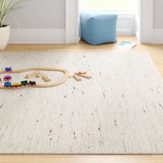 a child's toy train set laying on top of a rug