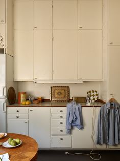 a kitchen with white cabinets and wooden table