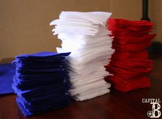 several stacks of folded cloths on a table