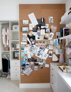 a cork board with pictures, photos and other things on it in a room next to a white dresser