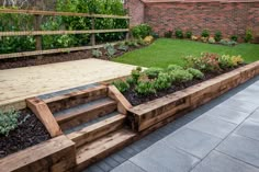 an outdoor garden with wooden steps leading to the back yard and green lawning area