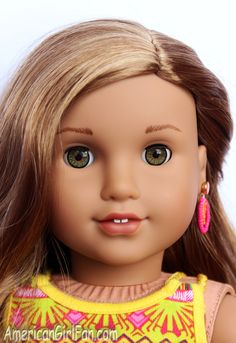 a close up of a doll's face with long blonde hair and green eyes