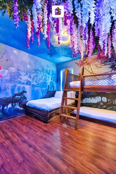 a bed room with two beds and purple flowers on the ceiling above it is a ladder that leads to another bed