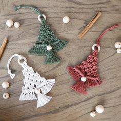 three crocheted ornaments on a wooden table with beads and wood dows next to them