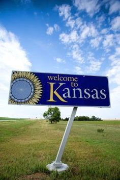 a welcome to kansas sign in the middle of a field