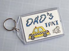 a cross stitch taxi cab keychain with the word taxi printed on it's side