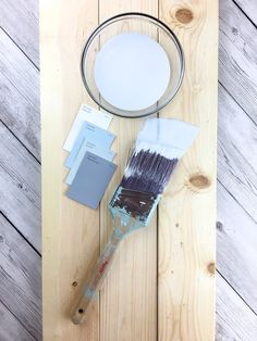 a paintbrush and some other items sitting on a wooden table with wood planks