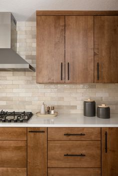 a stove top oven sitting inside of a kitchen next to wooden cabinets and counter tops