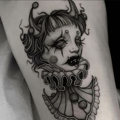 a woman's leg with a tattoo on it and an image of a demon