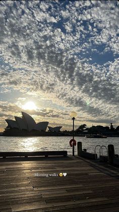 the sun is setting over the sydney opera house