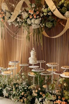 a table topped with lots of different types of cakes and desserts next to flowers