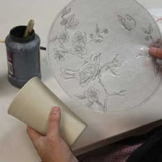 a person is painting on a plate with acrylic paint and some other things