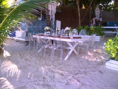 a table and chairs are set up in the sand