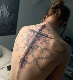 a woman with a cross tattoo on her back