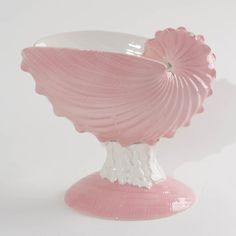 a pink and white vase sitting on top of a table