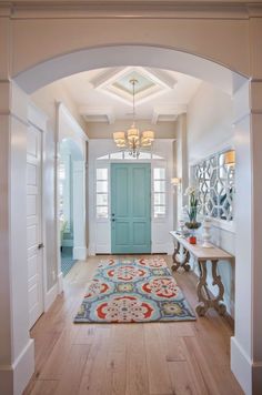 a blue door is in the middle of a hallway with white walls and wood floors