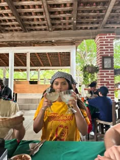 a woman drinking from a wine glass at an outdoor restaurant