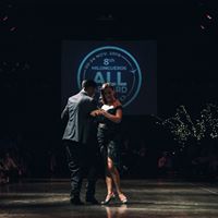 two people dancing on a stage at night