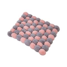 a pink and grey rug with pom - poms on the bottom, in front of a white background