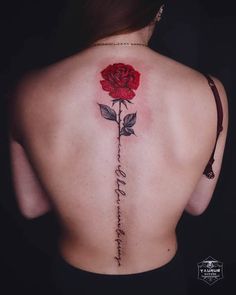 a woman's back with a rose tattoo on it