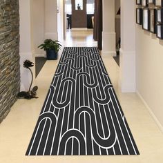 the hallway is decorated with black and white art work on the floor, along with pictures hanging on the walls