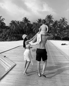 two people standing on a dock with towels over their heads, and one person in the foreground