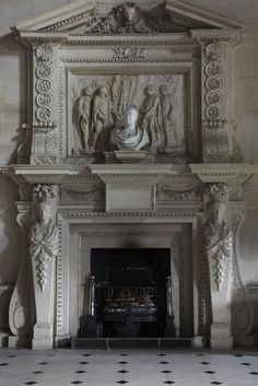 an ornate fireplace with statues on the mantle