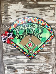 a baseball themed door hanger with the words see you at the ballfield