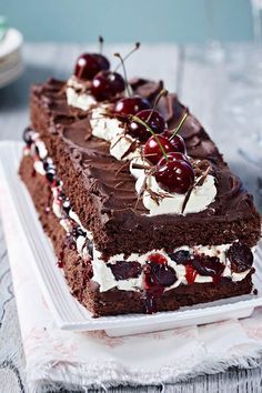 a piece of chocolate cake with cherries on top