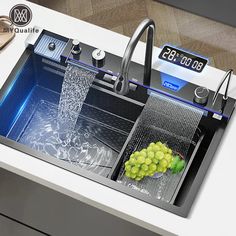 a kitchen sink that has some grapes on the bottom and water coming out of it