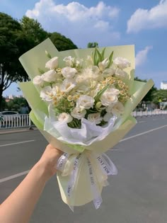 a person holding a bouquet of white flowers