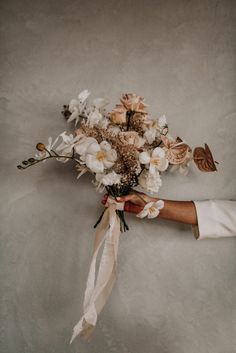 a bouquet of flowers being held by someone's hand