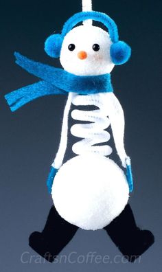 a snowman ornament hanging from a string on a blue and white background