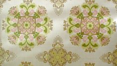 an old wallpaper with pink, green and yellow designs on white background that looks like it has been painted