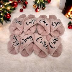 pink slippers with the words happy christmas written on them in front of a fireplace