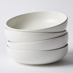 four white bowls stacked on top of each other