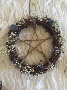 a star made out of twigs and baby's breath sits on a white rug